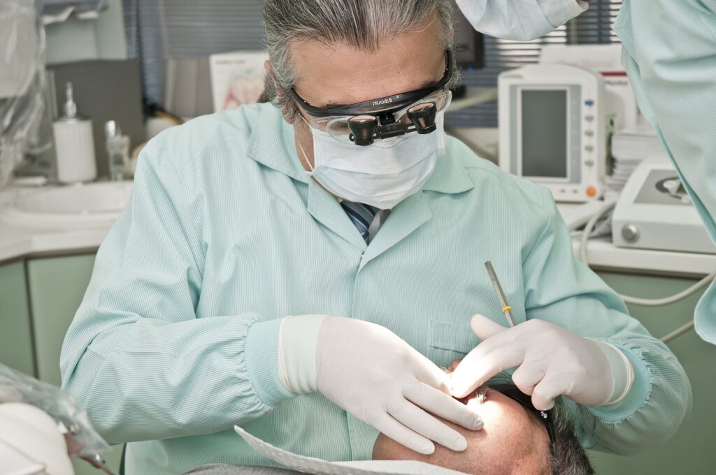 Older dentist working on a patient.