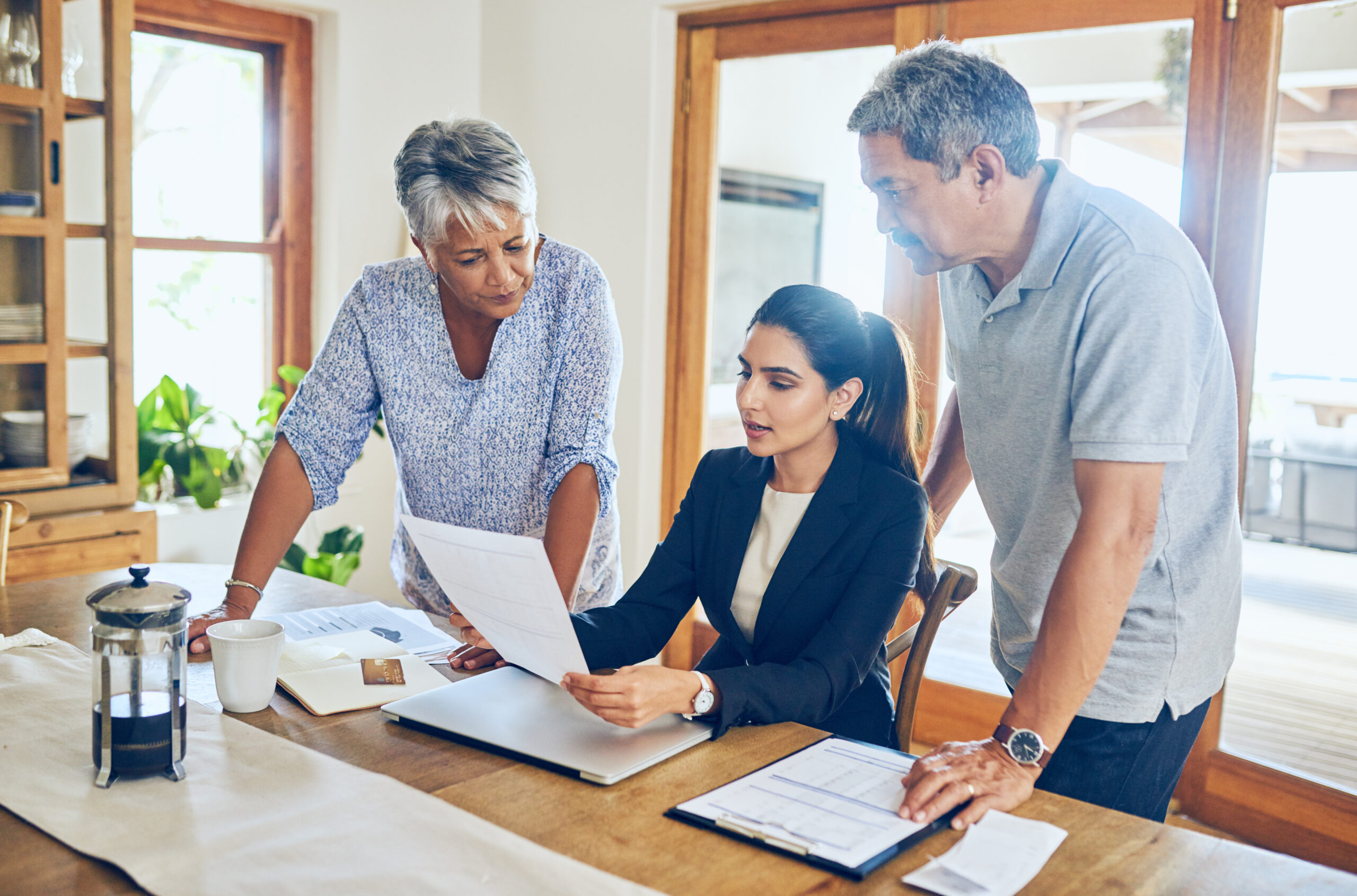 Two people work with an investment advisor looking over a report.